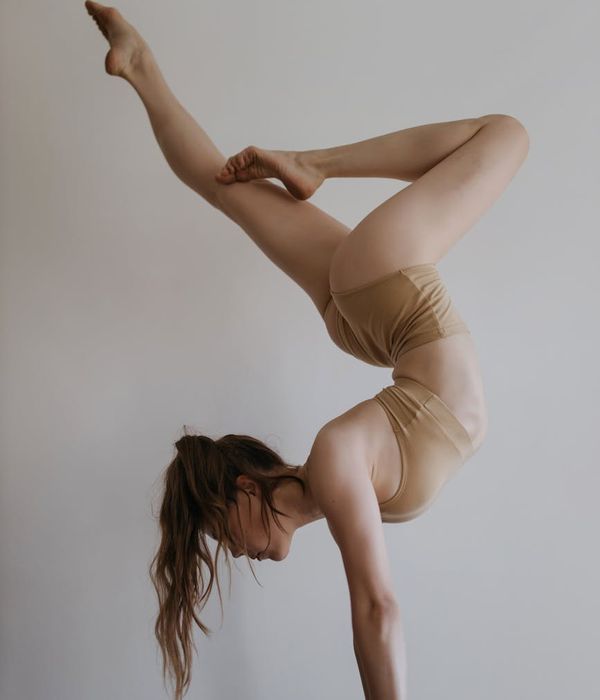 Woman performing a graceful yoga balance pose in warm lighting
